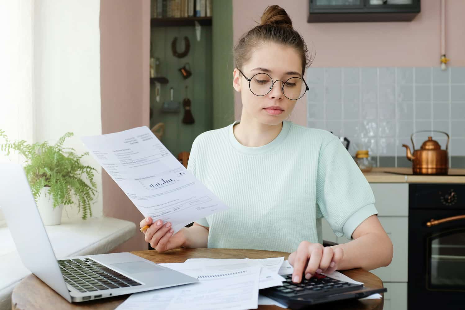 Woman calculating her budget on a calculator