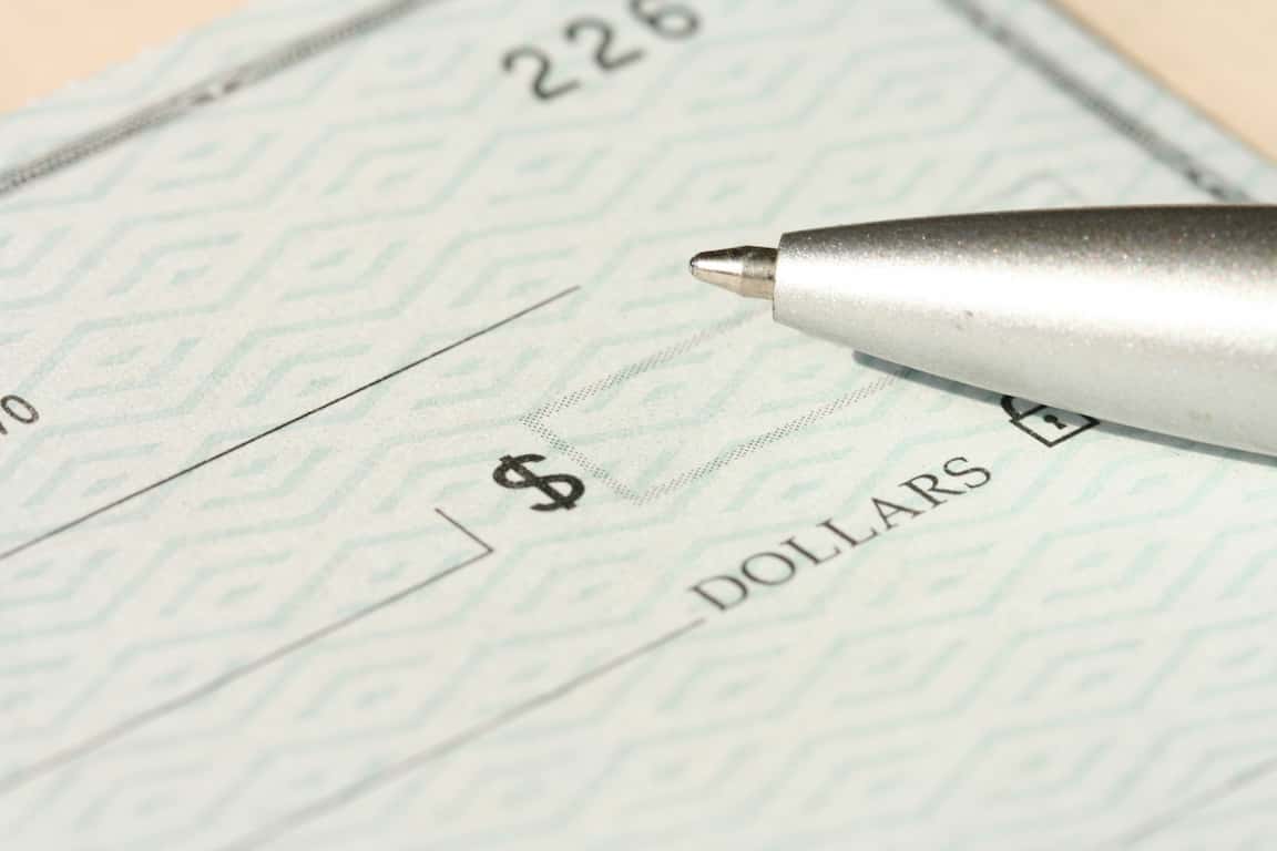 check with a pen on it, capital credits returns